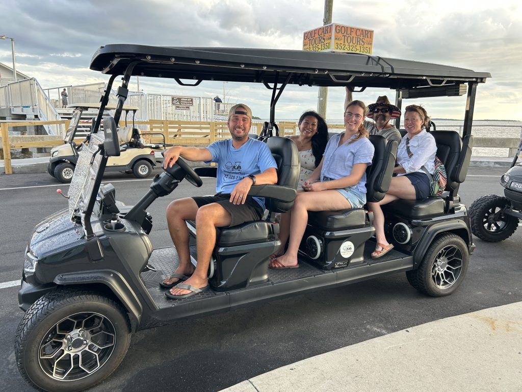 Guests enjoying a guided Cedar Key golf cart tour near the waterfront